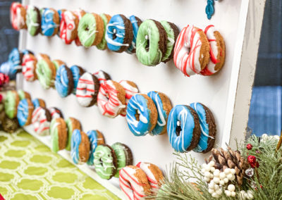 A display of donuts with different colors and flavors.
