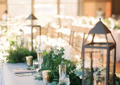 Candlelit wedding table with lanterns and greenery